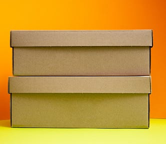 stacked brown paper boxes against a bright background