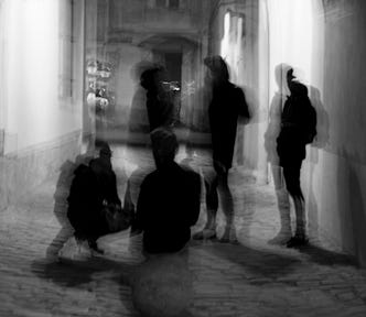 Black and white image of a group of people on a city street. The image is distorted and the people are blurred, making it seem surreal