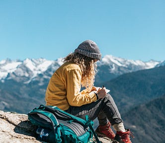Woman reading a book on a mountain top