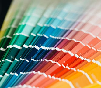 A full spectrum of paint swatches from green to yellow, symbolizing a rainbow