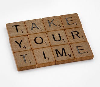 A set of Scrabble tiles that spell “TAKE YOUR TIME”