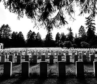 Black and white photo of a cemetery with uniform tombstones in the foreground.