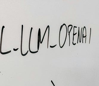 openAI scribbled in black marker on white board