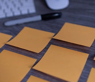 Yellow sticky notes lined up on a desk