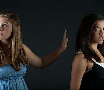 A teenager doing a “talk to the hand” gesture to another teenager, which makes me believe this photo must have been taken before the invention of the modern camera.