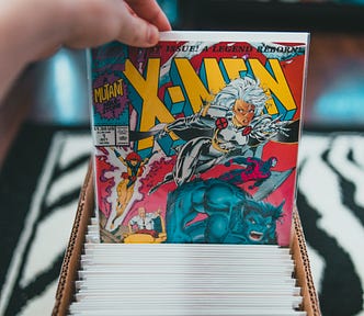 Somebody pulling an X-Men comic book from a box of comics.