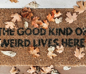 Door mat with the words ‘the good kind of weird lives here’ written on it