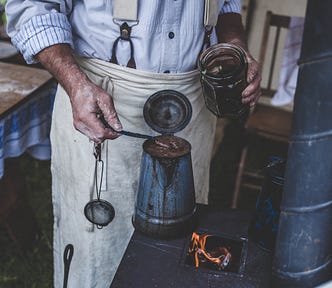 Craftsman making coffee on an old stove for article by Larry G. Maguire