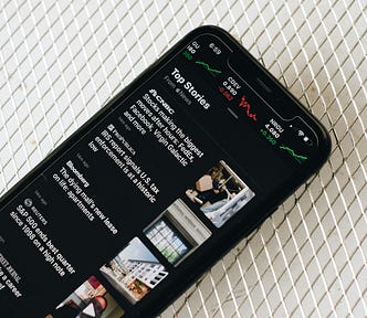 Photograph of smartphone with news items on screen