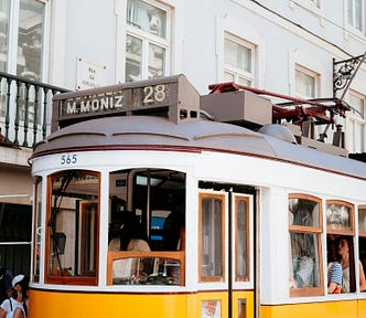 A white and yellow trolley car in Lisbon.