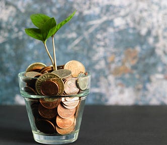 Tree buried in coins, growing in a cup