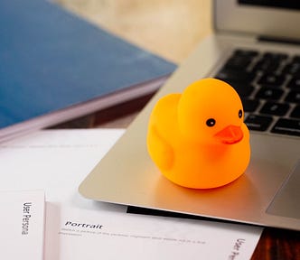 Rubber duckie sitting on a laptop.