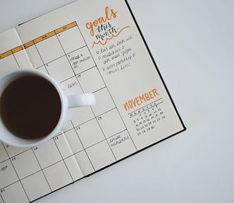 Coffee cup on top of an open calendar journal