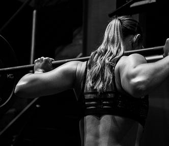A black and white photo of a woman lifting weights