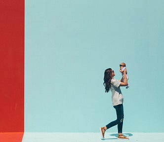 Woman walking while holding a baby up to face her