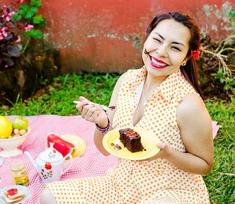 A writer eating chocolate cake outdoors