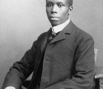 Formal portrait of Dunbar seated, wearing a suit and tie