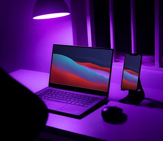 Computer on purple backlit desk next to iphone on stand