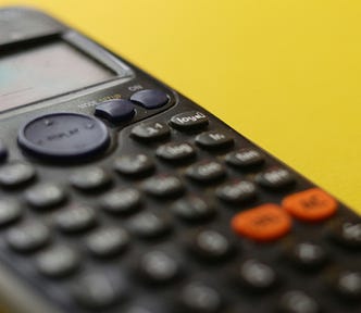 A near-threatening closeup of a calculator, buttons blurred.