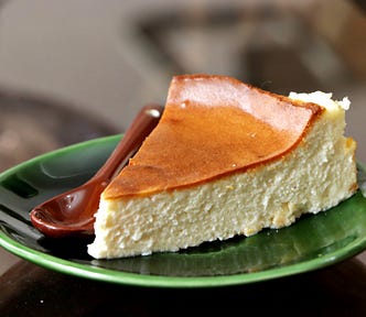 A photo of a single slice of cheesecake pie on a green dish