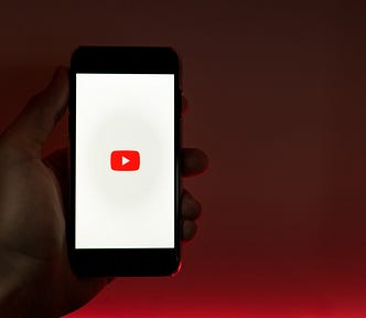 someone holding a youtube logo on their phone