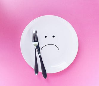 An empty plate with a sad face.