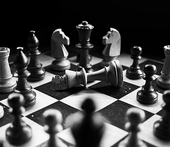 Black and white photo with a chessboard and chess pieces.