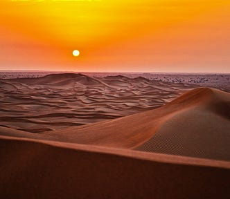 an artistic desert scene sunset, with a glowing orange sky