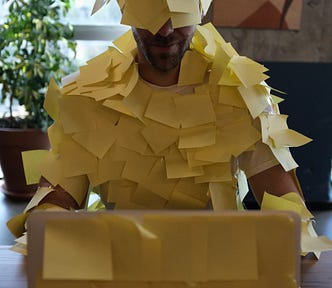 A man covered with yellow sticky notes. The devourer of free time