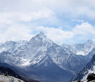 Mountains with snow, blue sky, and clouds