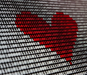 A stream of white 0s and 1s fills a black computer screen, and in the middle the numbers turn to red in the shape of a heart