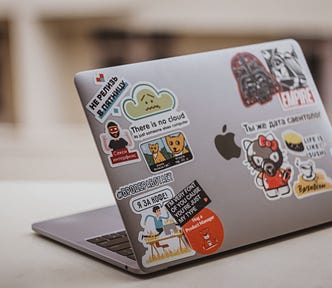 Laptop with stickers. What does a Product Manager do? The skills you need to build to become a Product Manager. Photo by Lala Azizli on Unsplash