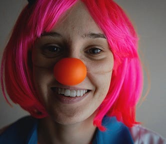 women wearing a plastic orange nose and a pink wig