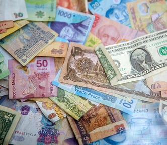 A photo showing money. There is currency note. All countries currency notes are on there.