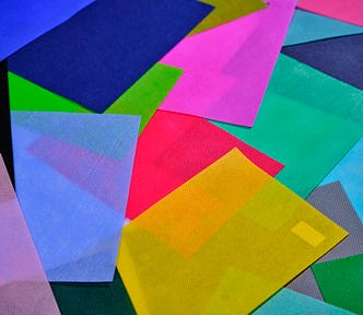 Colorful sheets of paper, in a disorganized pile