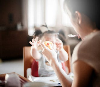 A mother feeding a child