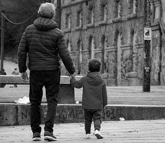 A father and son walking in a city