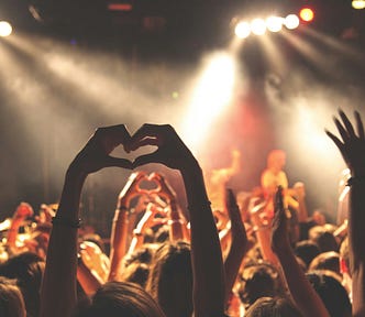Heads and raised hands of clubbers in a crowded club.