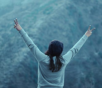 A woman with her arms outstretched in a victory pose.