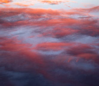 Pink sunset clouds against a blue background.