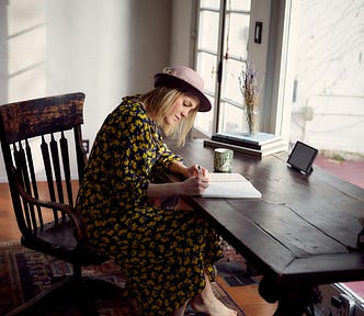 A writer writes at her writing desk