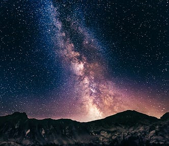 Photo of stars above the mountain tops.