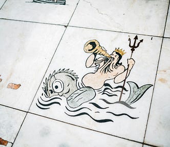 Mosaic of Poseidon riding a top a sea creature, while sounding a horn