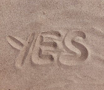 “Yes” drawn in the sand.