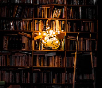 A bookshelf illuminated by a star-shaped lamp.