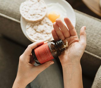 A person with a supplement bottle in their hand