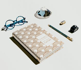Novel — Gatsby, with glasses and a pen.