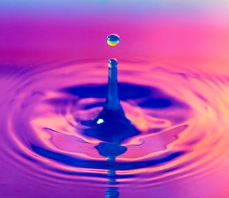 a drop of water causing a ripple effect in a pond of water — all hot pink and purple in color