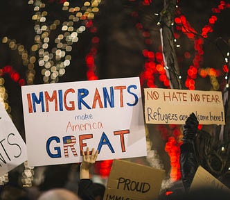 Cardboard signs saying ‘Immigrants make America great’.