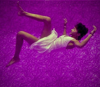 Sleeping woman falling through purple dreamlike world